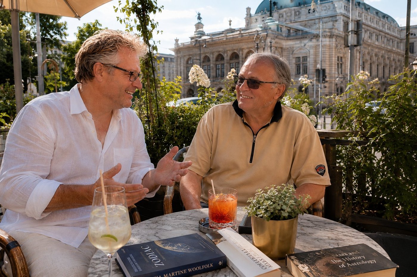 Vienna Ringstrasse cafe terrace on the first warm afternoon of June with Bernhard Mann, mid-sentence about the precession of the equinoxes, three illustrated books on the history of astrology on the marble table including Zodiac by Martine Woolfolk and Stars and the History of Astrology, an Aperol Spritz and a Hugo, the back of a rose garden, the classical facade of the Burgtheater rising behind the trees on the Universitatsring with its characteristic green-copper dome and crowning statue, Radim Kaufmann in a crisp white linen shirt with sleeves rolled to the elbows, Bernhard in a beige polo, both relaxed in conversation, late afternoon sun filtering through the foliage.