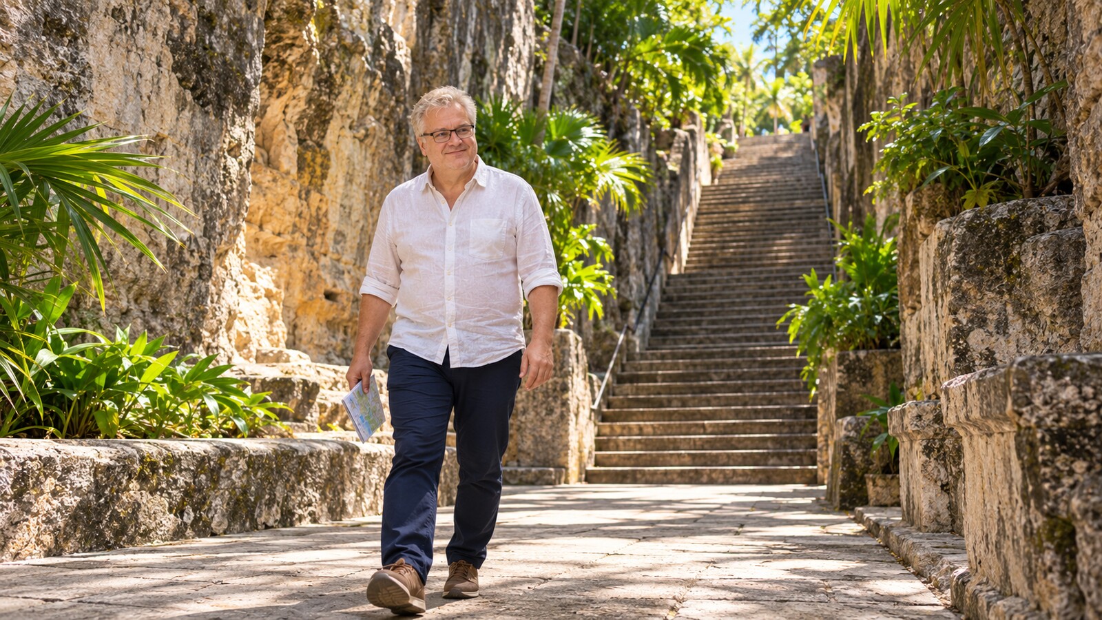 Radim Kaufmann walking beside the limestone walls and tropical greenery of the Queen's Staircase in Nassau