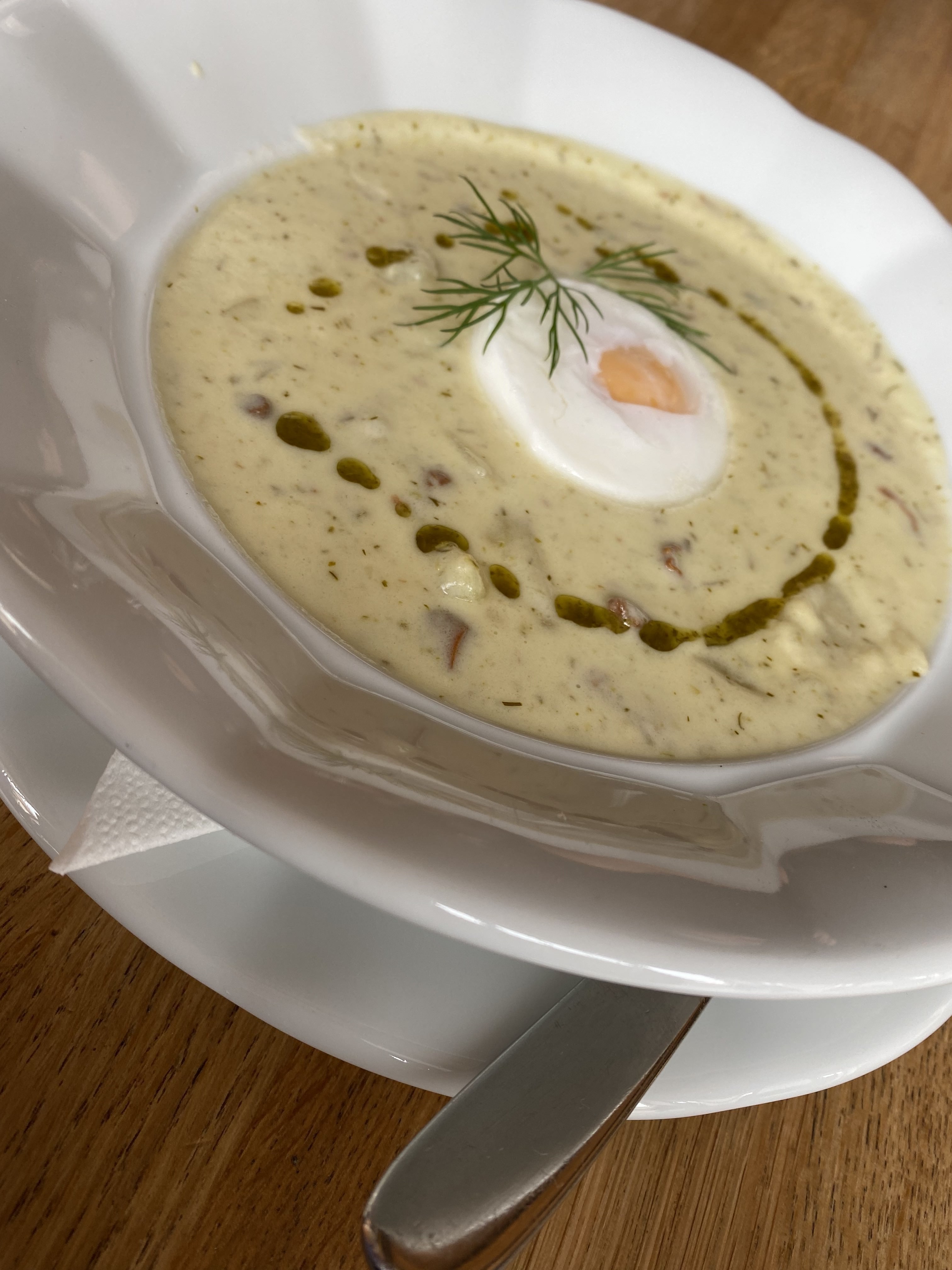 Bowl of kulajda soup with poached egg and dill
